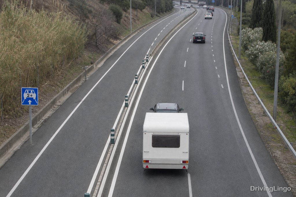 Autovía A-6 de seis carriles con un carril reservado separado por marcas, vista desde un paso elevado