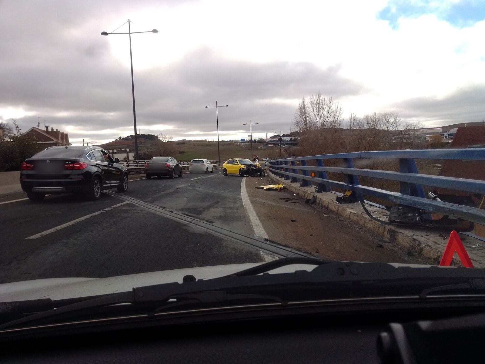Colisión junto a la barrera de seguridad de una carretera, vista desde un coche que se acerca