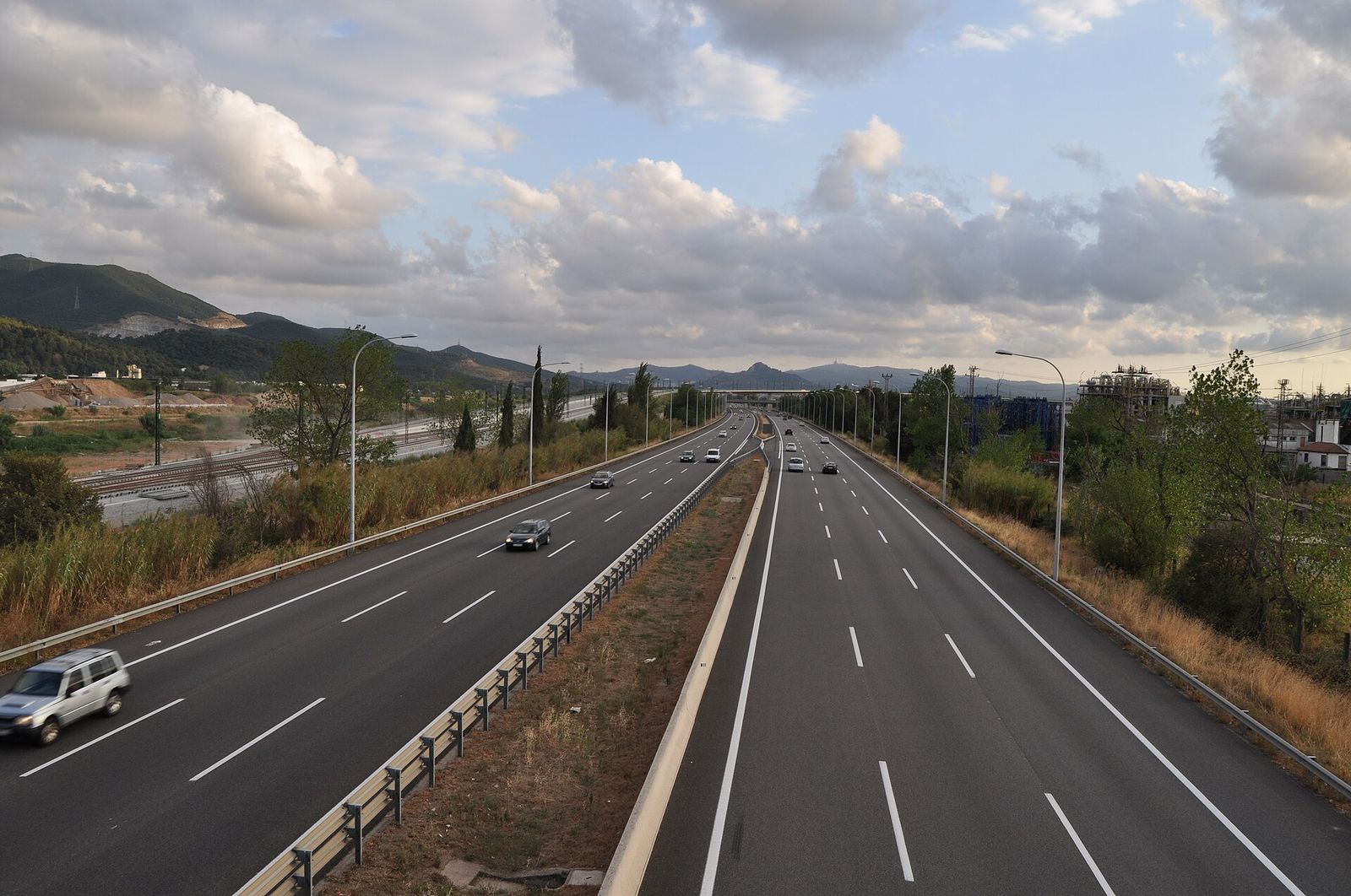 Autopista de varios carriles por sentido con mediana, vista desde un paso elevado