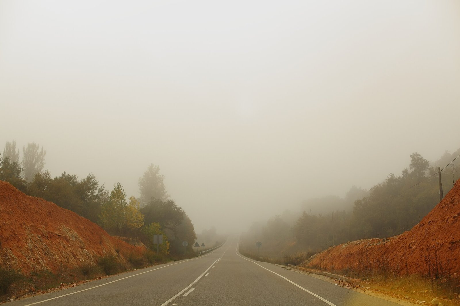 Carretera convencional con niebla densa, vista desde el coche